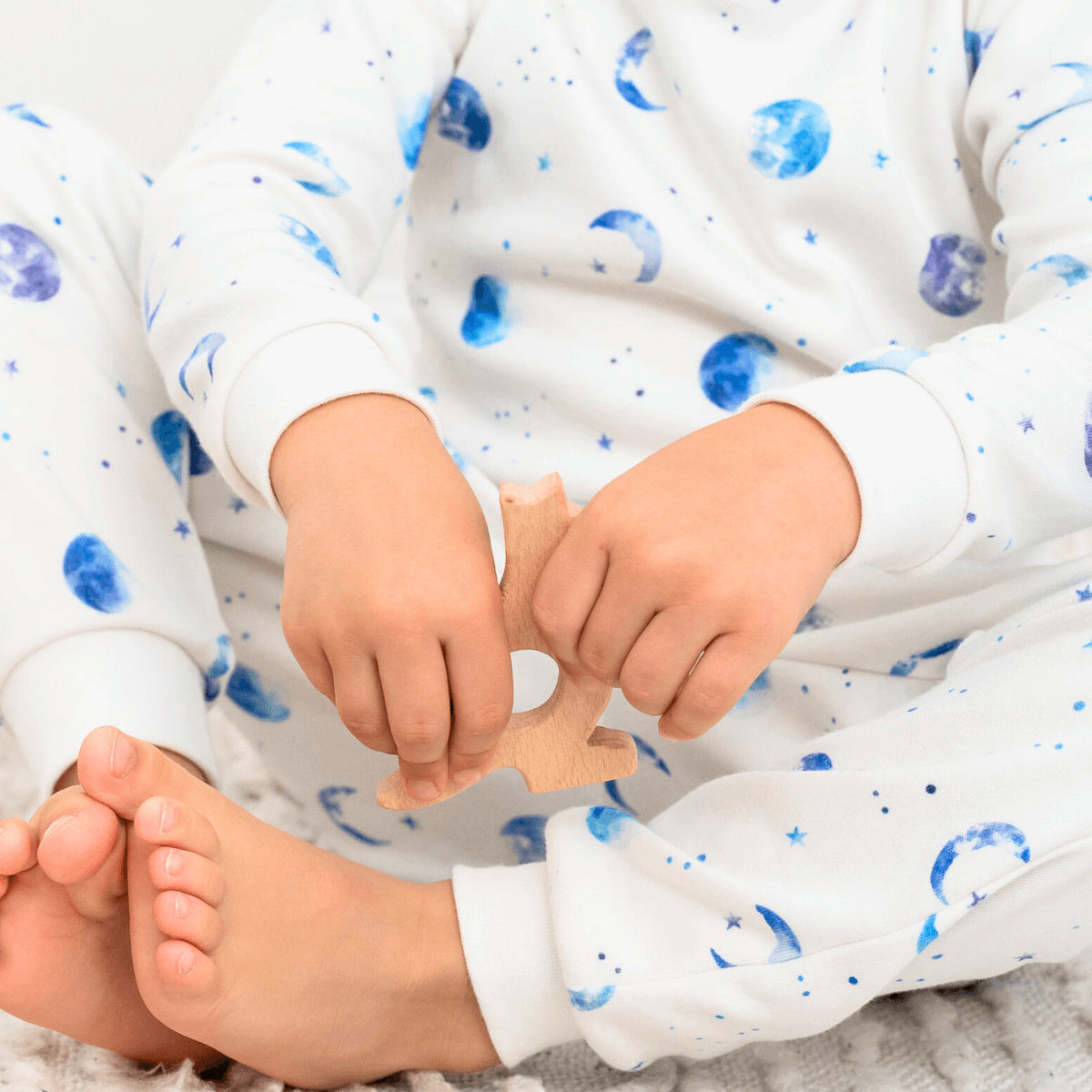 Close up of child wearing the Marvellous Moons Pyjamas with blue moon, planet and constellation print made from bamboo and organic cotton from GrowGrows