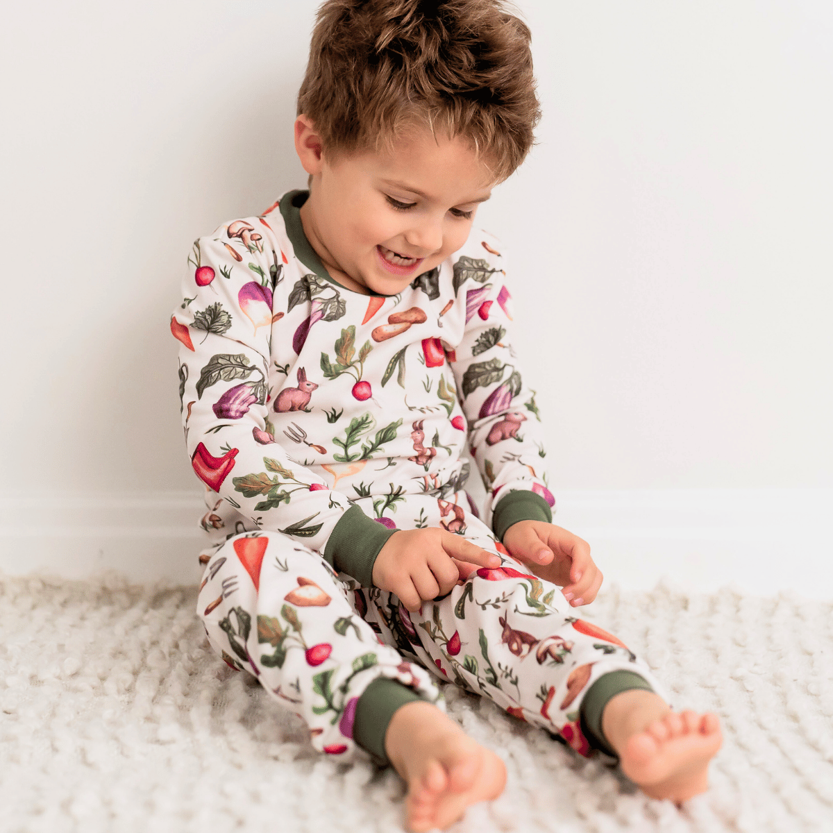Child wearing the colourful Allotment Adventure Pyjamas with vegetable allotment print made from bamboo and organic cotton from GrowGrows