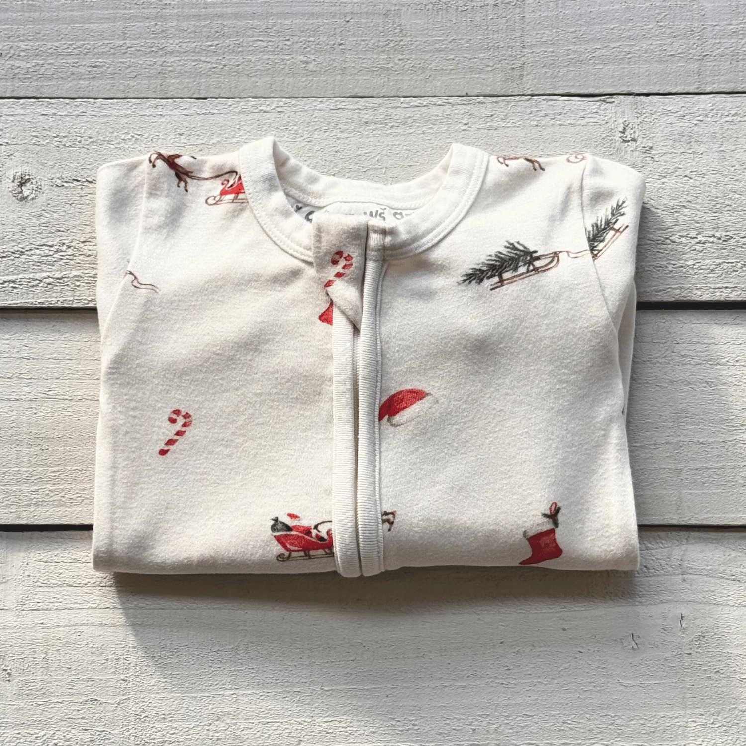 Folded Christmas Eve Sleepsuit with Santa and reindeer print from GrowGrows