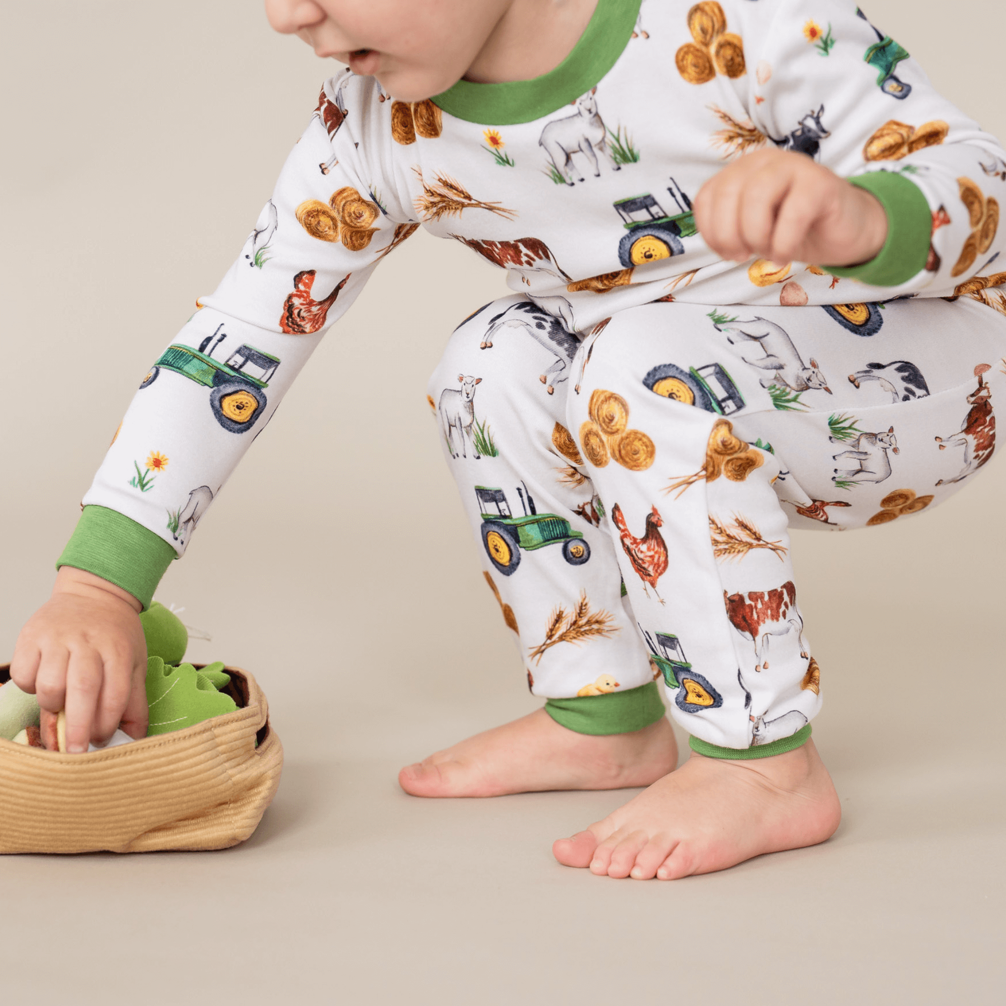 Close up of young boy wearing the Family Farm Pyjamas with farmyard animal and tractor print made from bamboo and organic cotton from GrowGrows