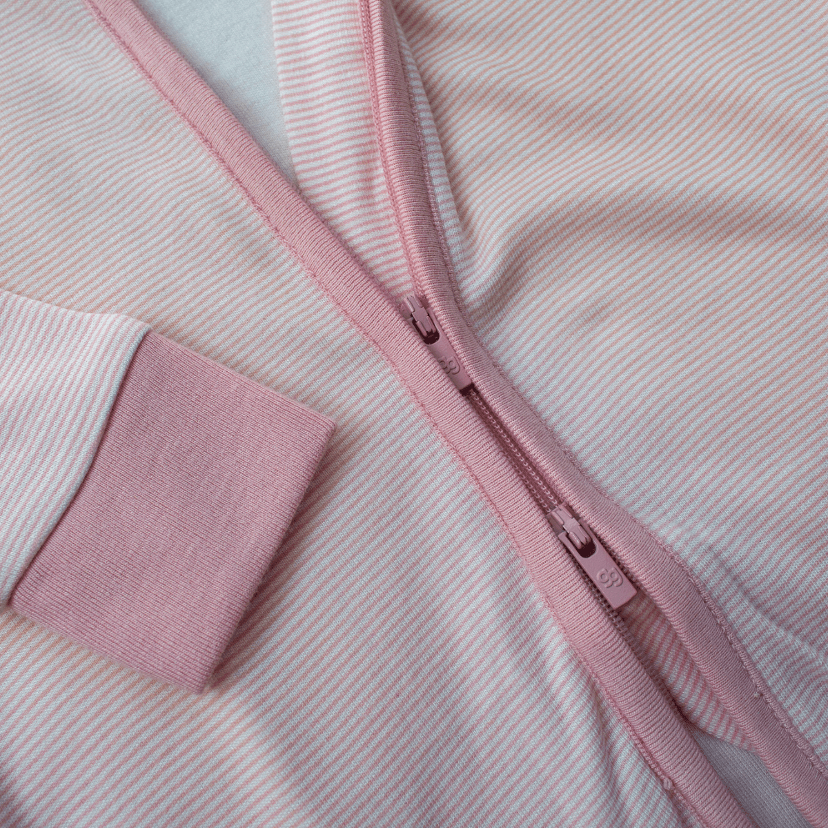 Close up of the 2-way zip on the Pink Pinstripe Sleepsuit with classic pink stripe design made from bamboo and organic cotton from GrowGrows