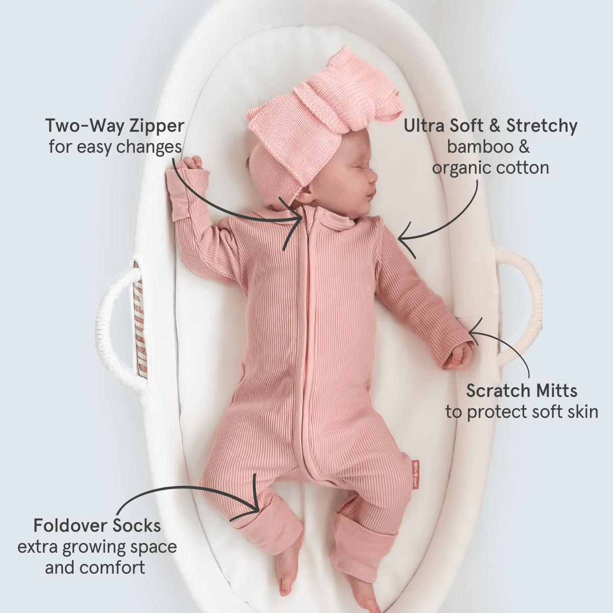 baby lying in the Moses basket wearing the Blush Ribbed Sleepsuit made from bamboo and organic cotton from GrowGrows with key features highlighted