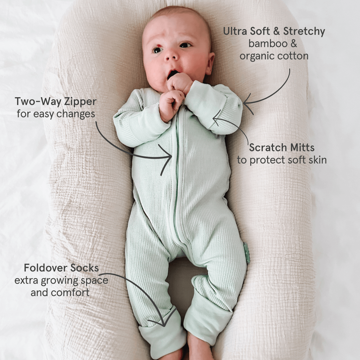 Baby wearing the Sage Ribbed Sleepsuit made from bamboo and organic cotton from GrowGrows with key features highlighted