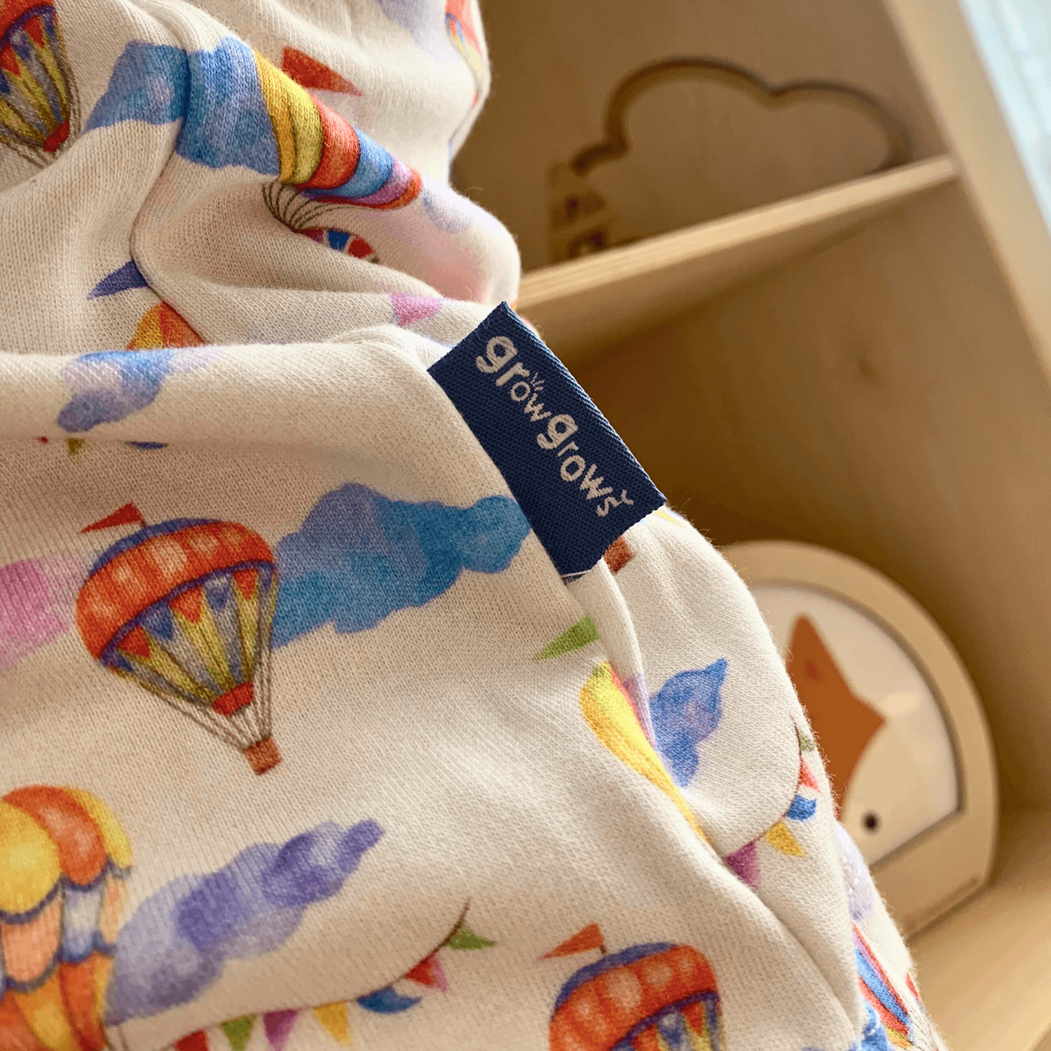 Up, Up & Away Sleepsuit with hot air balloon and cloud print made from bamboo and organic cotton from GrowGrows close up of the hand-drawn print and label