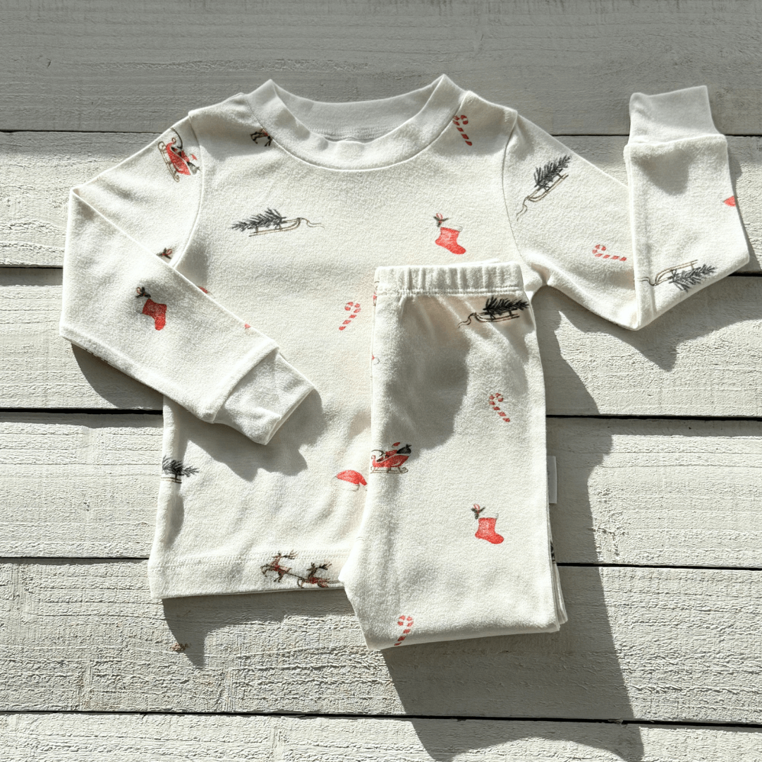 Christmas Eve Pyjamas with Santa and reindeer print made from bamboo and organic cotton from GrowGrows on a wooden background