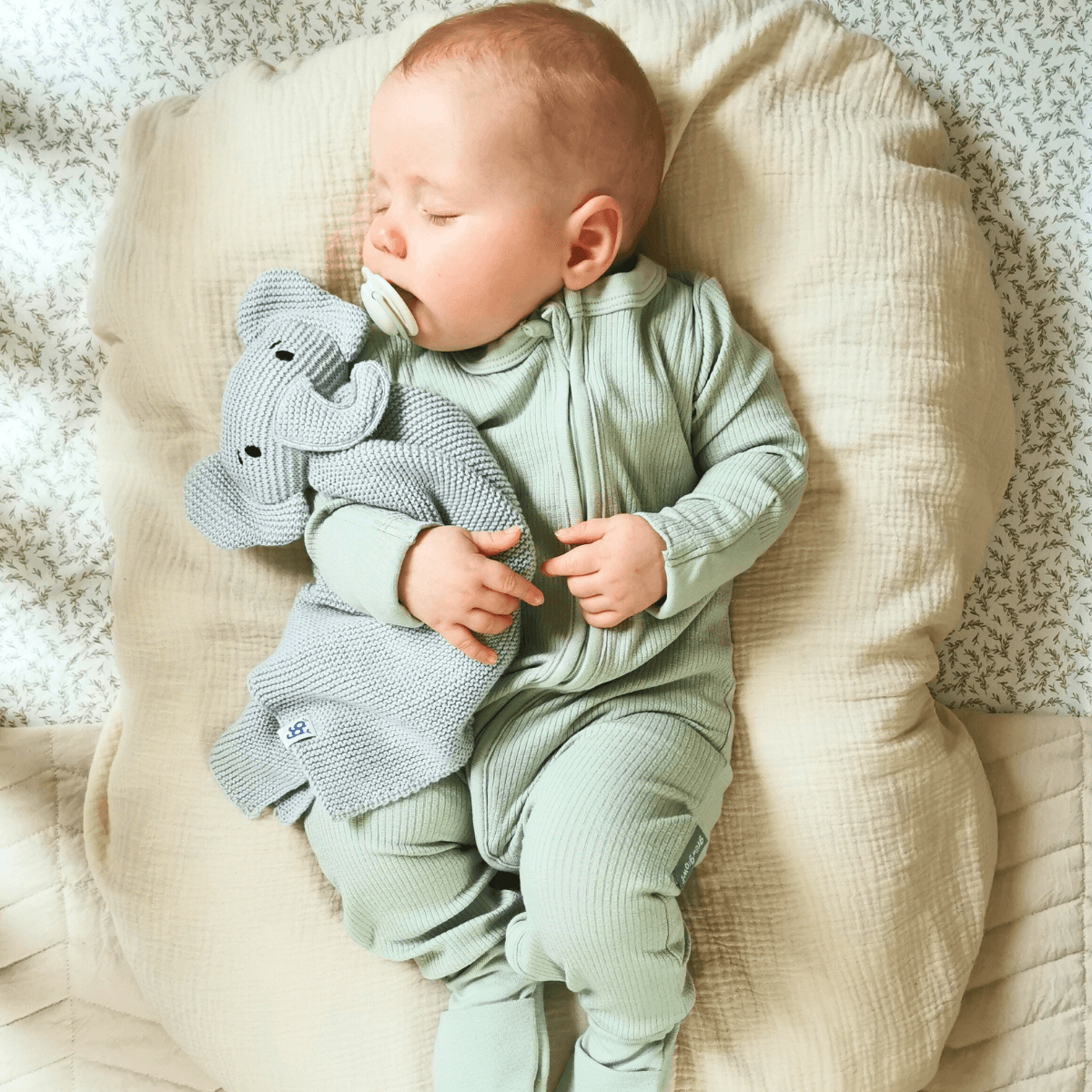 Newborn baby snuggled up wearing the Sage Ribbed Sleepsuit | Bamboo Baby Clothes - GrowGrows