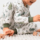 Close up of child wearing the Country Leaf Pyjamas with green botanical leaf print on a white background made from bamboo and organic cotton from GrowGrows