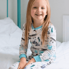 Girl sat on the bed wearing the Arctic Animals Pyjamas with Arctic animal print made from bamboo and organic cotton from GrowGrows