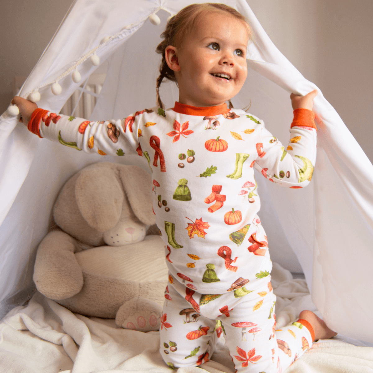 Toddler wearing the Autumnal Amazes Pyjamas with pumpkin and autumn print made from bamboo and organic cotton from GrowGrows