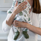 Close up of mum holding baby wearing the Country Leaf Sleepsuit with leaf print and integrated foldover socks from GrowGrows