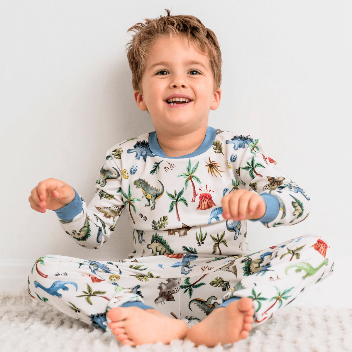 Child wearing the Dandy Dinos Pyjamas with dinosaur print made from bamboo and organic cotton from GrowGrows