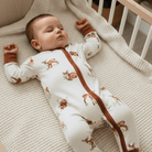 Baby lying on a textured blanket wearing the Fleeting Fawn Sleepsuit with fawn print made from bamboo and organic cotton from GrowGrows