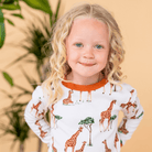 Child wearing the Gentle Giraffes Pyjamas with giraffe print made from bamboo and organic cotton from GrowGrows