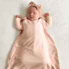 Newborn baby resting in the Pink Pinstripe Smart Sleeping Bag with pink pinstripe design made from bamboo and organic cotton from GrowGrows