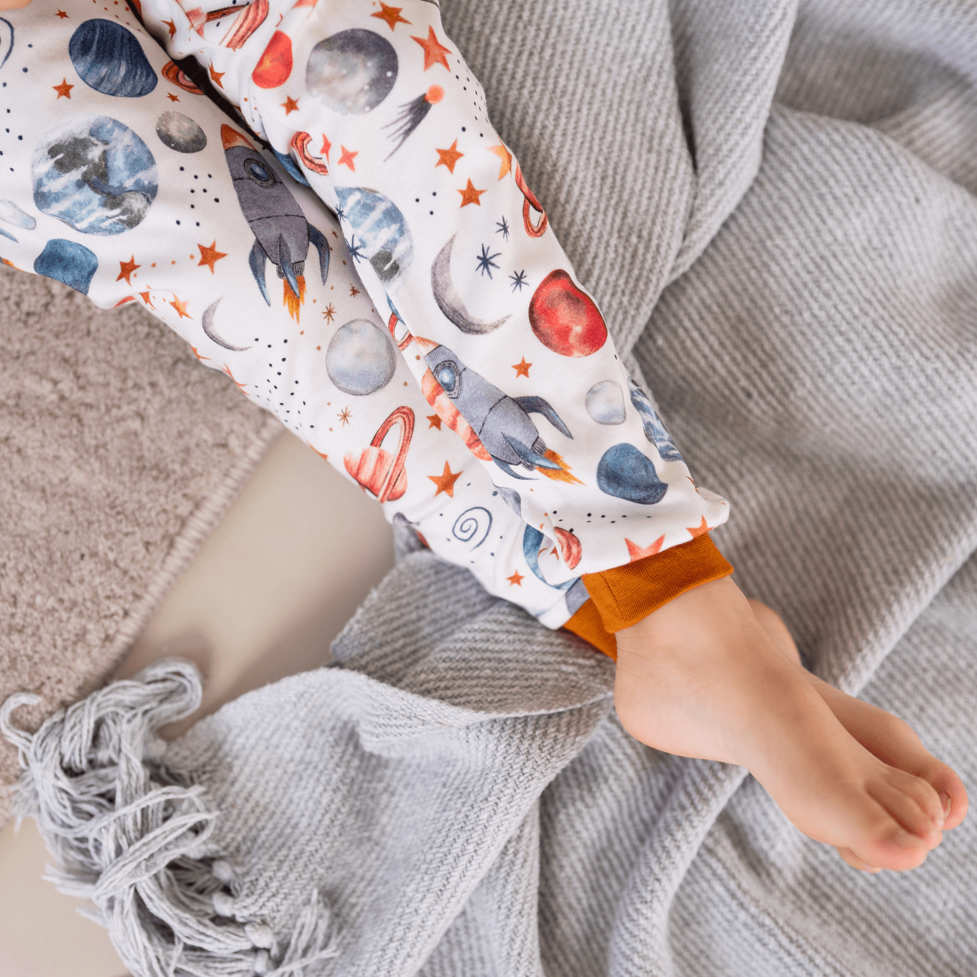 Close up on the ribbed coff and rocket ship watercolour print on the Plentiful Planets Pyjamas with planet and space print made from bamboo and organic cotton from GrowGrows