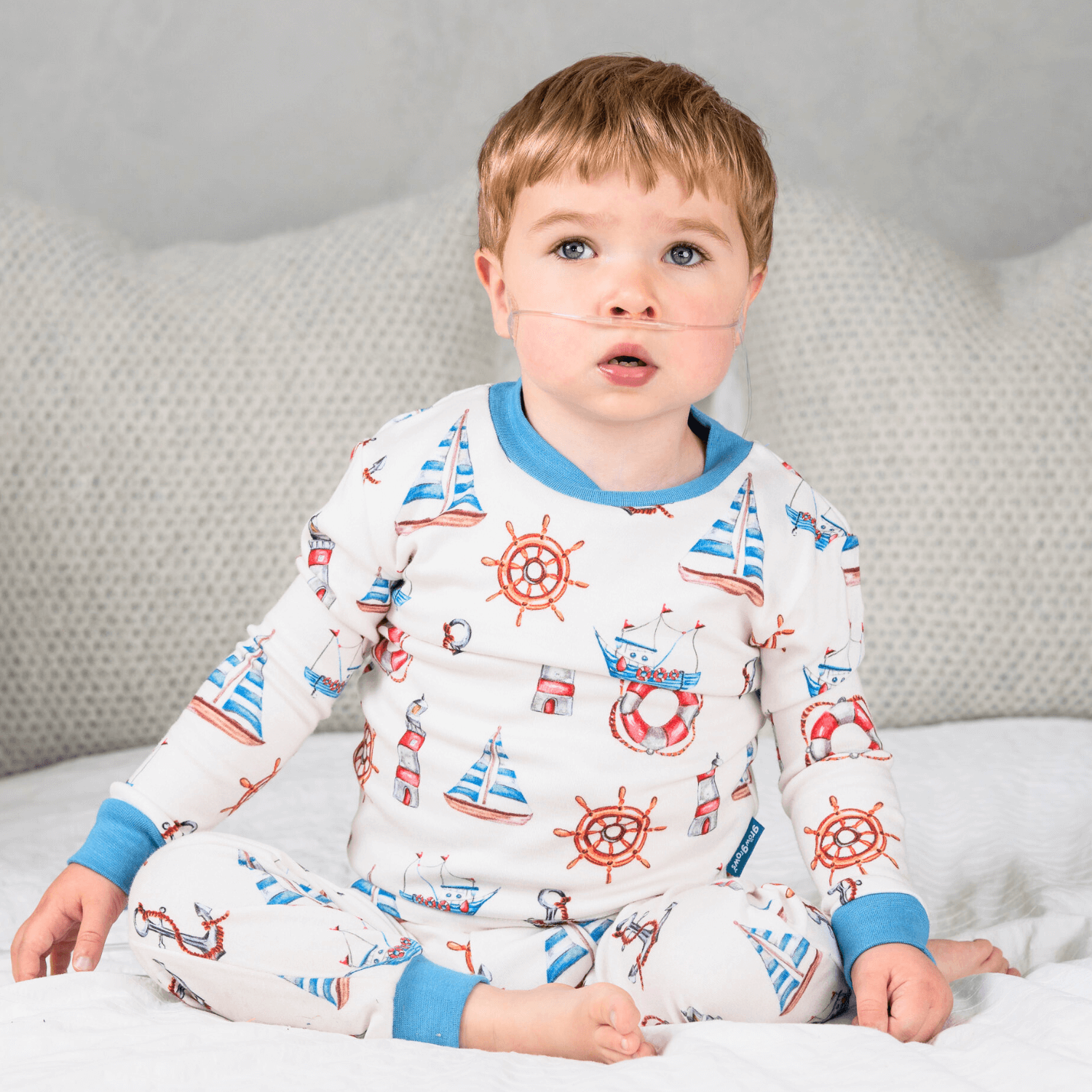 Young boy wearing the Seaside Sailor Pyjamas with nautical sailing print made from bamboo and organic cotton from GrowGrows