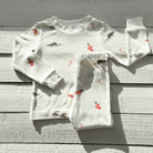 Christmas Eve Pyjamas with Santa and reindeer print made from bamboo and organic cotton from GrowGrows on a wooden background